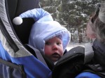 Jízda na běžkách leden 2004, hodně mrzne, Kamča má 7 měsíců, na obličeji krém proti větru a mrazu a na nohách na kombinéze jako vrstvu navíc místo spacího pytle ještě oteplovačky na dvouleté dítě